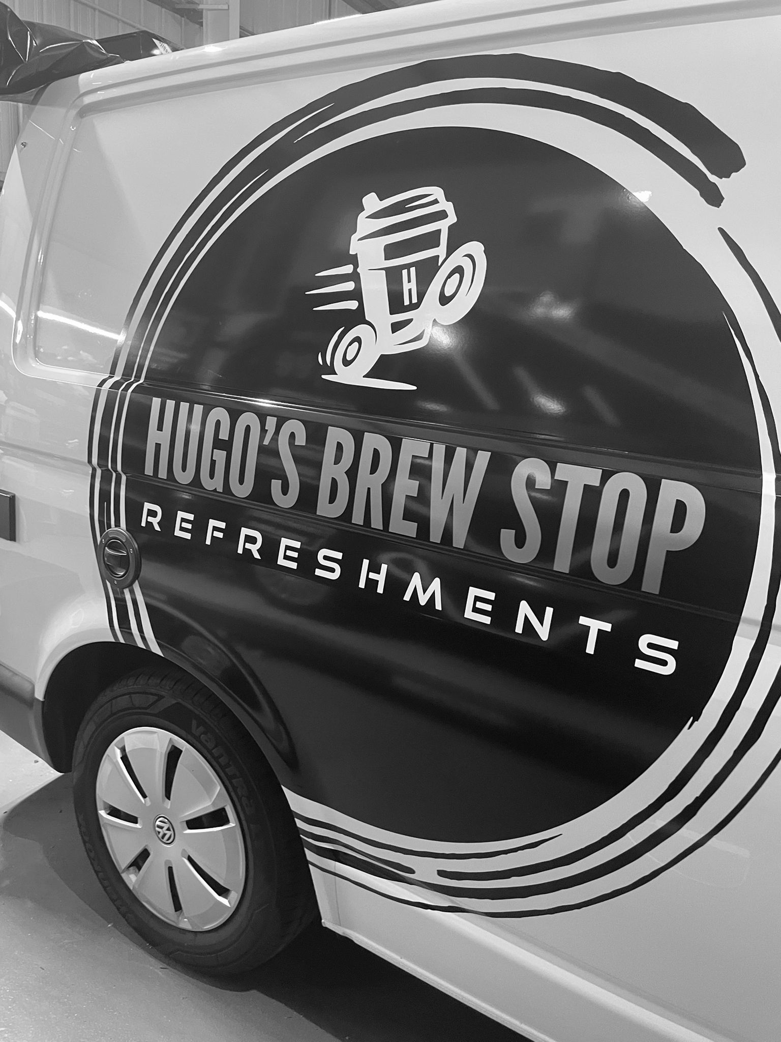 Side view of van with text 'Hugo's Brew Stop'